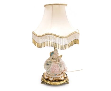 A Capodimonte porcelain figural table lamp, modelled as an 18thC lady seated reading a book to a child, raised on a Rococo st