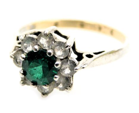 A 9ct gold and silver flowerhead cluster ring, set with a central green stone within a petalled border of eight white stones,