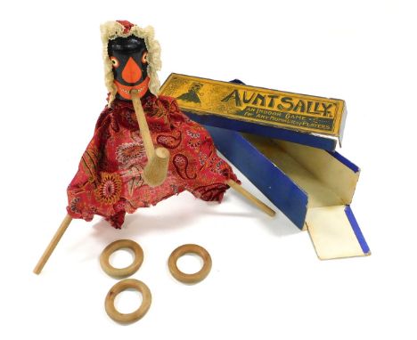 A late 19thC game of Aunt Sally, with a painted wooden and fabric bound figure, hoops, poles and pipe, boxed.
