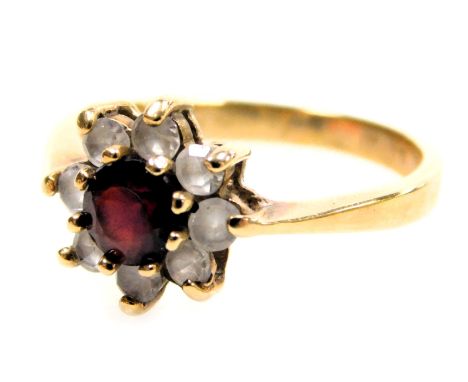 A 9ct gold flowerhead cluster ring, with a central brilliant cut ruby, surrounded by eight tiny white stones, 2.14g all in.