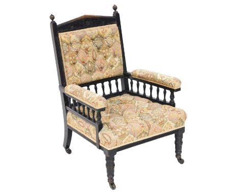 A Victorian ebonised library chair, upholstered in button back floral fabric, raised on turned legs, on castors, 61cm wide.
