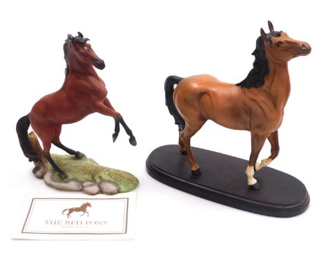 A Beswick matt brown pottery figure of a horse, modelled with its head and front left leg raised, raised on an oval base, 23c