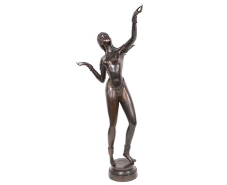 A late 20thC bronze figure of an exotic dancer, adorned with a jewelled necklace and G string, her arm outstretched, on a cir