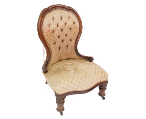 A Victorian mahogany spoon back nursing chair, upholstered in button back and over stuffed floral fabric, raised on turned le