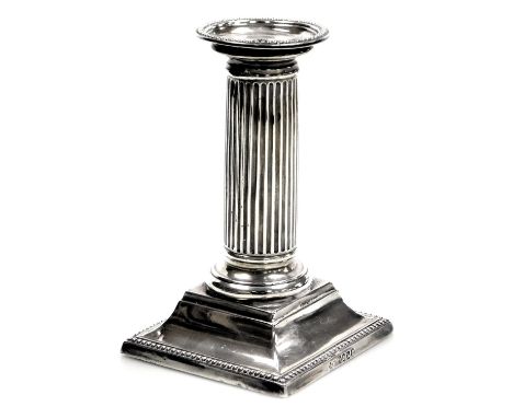 A Victorian silver Doric column candlestick, with detachable sconce, having beaded borders and square filled base, 13cm high,