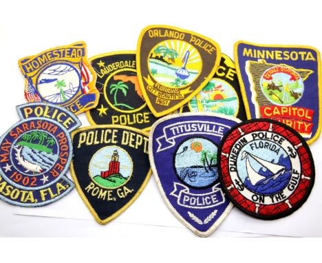 A collection of mostly American Police Department sleeve patches, including Orlando, Sarasota and Lauderdale Lakes. P&amp;P G