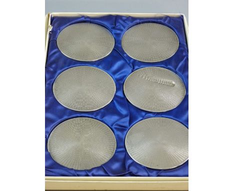 A CASED SET OF SIX SILVER ENGINE TURNED WINE COASTERS, Birmingham 1974 (severe impact damage to the surface of one)