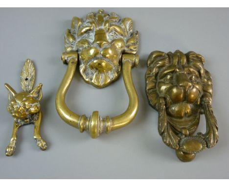 A HEAVY LION'S MASK DOOR KNOCKER, 23 cms long, a further similar, 17 cms long and a brass fox door knocker, 15 cms long