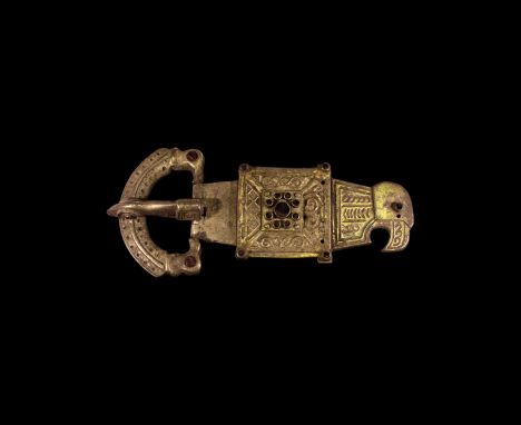 5th century AD. A parcel-gilt silver buckle comprising: a crescent loop with bird-head finials, punched-point detailing and c