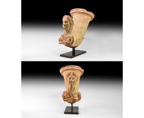 3rd century BC-2nd century AD. A terracotta rhyton with flanged and stepped rim, tapering curved body, figural finial of the 