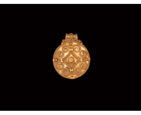 10th-12th century AD. A gold disc pendant with applied filigree and granule cross flory motif with central boss, integral loo