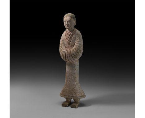 Han Dynasty, 206 BC-220 AD. A ceramic figure of a courtly attendant with short hair, layered robes with V-shaped necklines, h