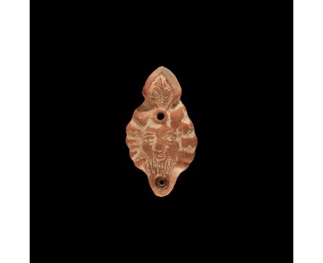 2nd-3rd century AD. A large terracotta oil lamp with discus and shoulder formed as a solar(?) mask with radiating panels to t