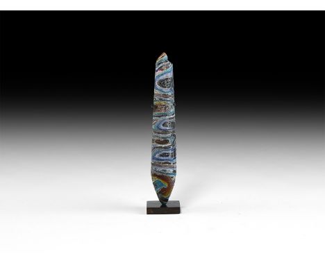 1st century BC-1st century AD. A slender alabastron of marbled polychrome glass, with conical base and tapering body; mounted