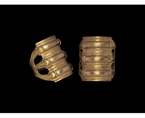 5th century AD. A gold finger formed as three curved serpents on a field with beaded wire borders, the heads conjoined at eac