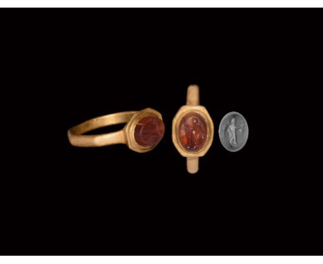 2nd century AD. A gold finger ring comprising an octagonal D-section hoop, flared bezel with inset carnelian cloison, intagli