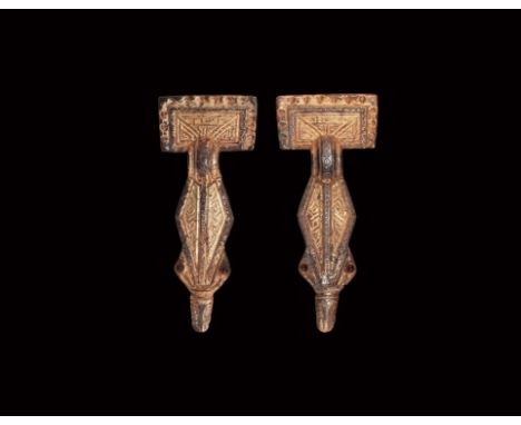 6th century AD. A matched pair of silver-gilt bow brooches, each with rectangular headplate and geometric detailing, short bo