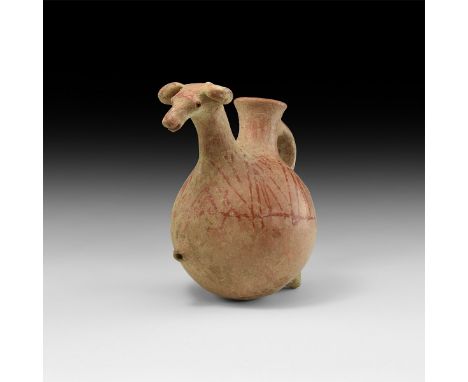 1st millennium AD. A ceramic aquamanile formed as a standing caprid with head on a long arched neck, painted linear detailing