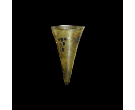 5th-8th century AD. A conical amber glass lamp with rounded rim, opposed clusters of applied blue glass pellets with larger p