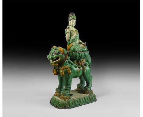 Ming Dynasty, 1368-1644 AD. A glazed ceramic statue of a lion with open mouth on a rectangular lotus flower base, supporting 