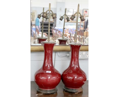 A Pair of Chinese Sang de Boeuf Vases, mounted as table lamps, each with two branches and on wood plinth, porcelain 38cm Vase