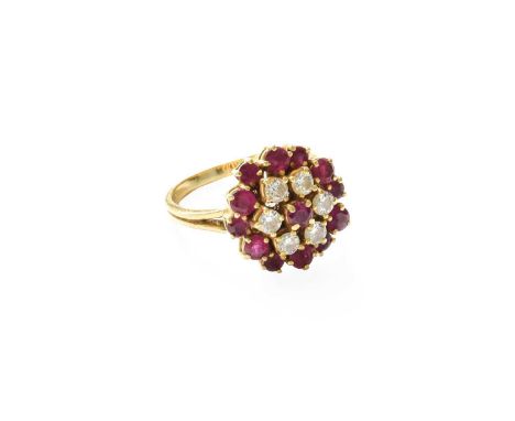 An 18 Carat Gold Ruby and Diamond Cluster Ring, the central round cut ruby within a border of round brilliant cut diamonds, t