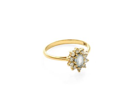 An 18 Carat Gold Aquamarine and Diamond Cluster Ring, the oval cut aquamarine within a border of round brilliant cut diamonds