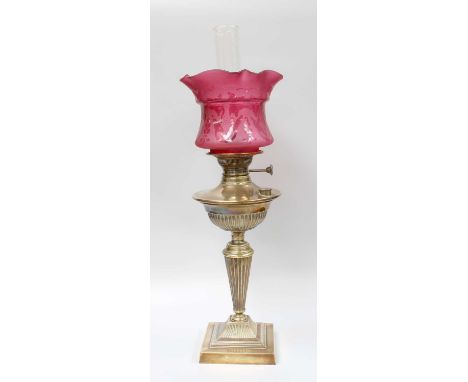 A Victorian Brass Based Oil Lamp, with etched cranberry glass shade and on fluted pedestal    Shade is in good condition with