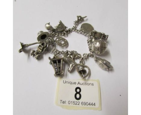 A silver charm bracelet with 15 interesting charms, four open, a boxing glove, vintage car, boat etc.,