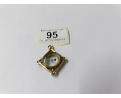 A gold compass pendant.