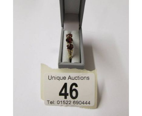 A vintage 3 stone garnet ring set in 18ct gold, size M.