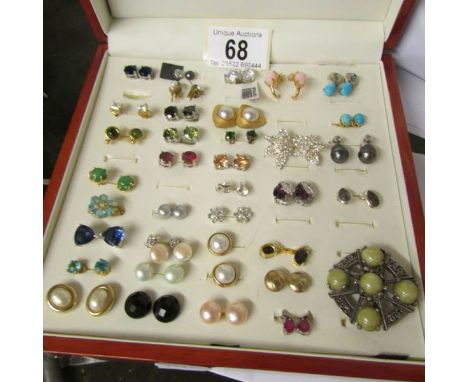A case containing approximately 34 pairs of earrings including turquoise and pearl.