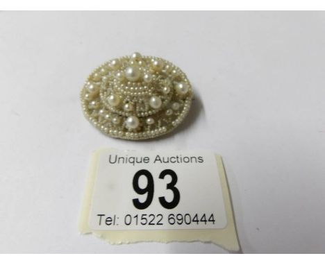 A pearl set oval brooch.