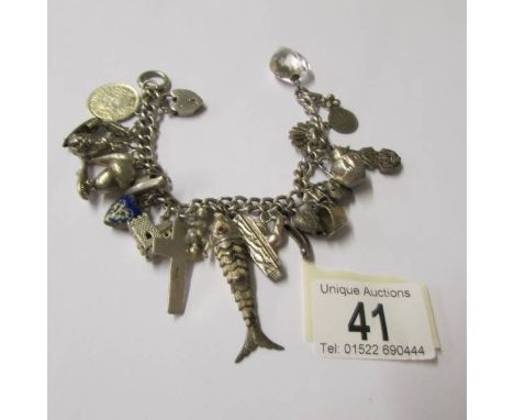 A vintage charm bracelet with a variety of mostly silver charms, some opening, one for Chester, enamelled heart charm, 25 in 