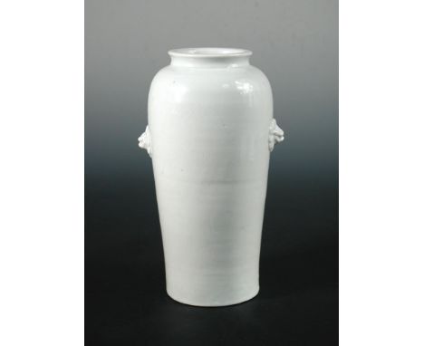 A 17th century blanc de Chine vase, a cavetto neck above rounded shoulders to a tapering cylindrical body moulded with lion m