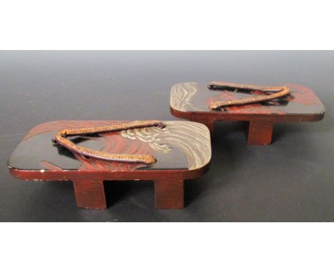 A pair of lacquered geta, the left foot with the head of a red dragon on a black ground, the right foot with the body, both a