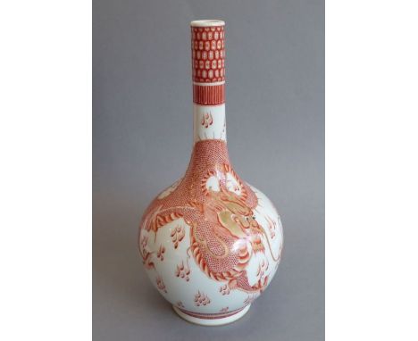 A Chinese porcelain bottle vase; hand-gilded and decorated with a large and sinuous four-clawed dragon chasing the flaming sc