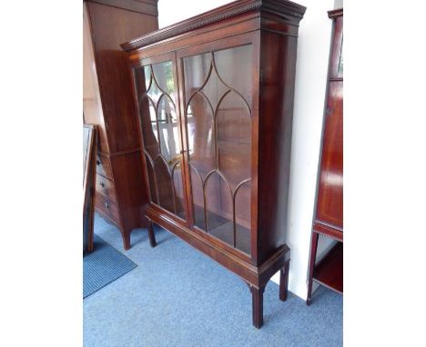 A George III period mahogany display cabinet; dentil cornice above two glazed doors with astragal glazing bars enclosing shel