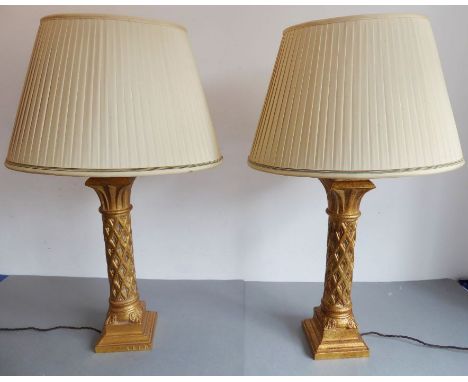 A pair of large and heavy table lamps and shades by the Original Lighting Company Ltd, the gilded style columns with latticew