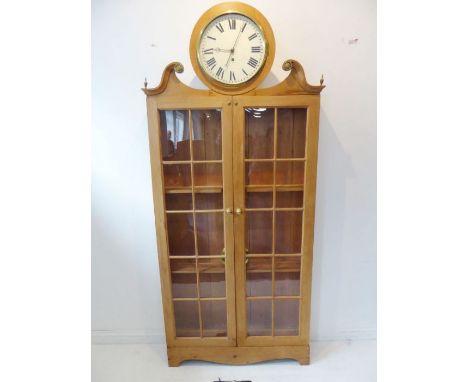 A 19th century pine housekeeper's type cupboard; the central clock with cream-enamel dial with Roman numerals between a broke
