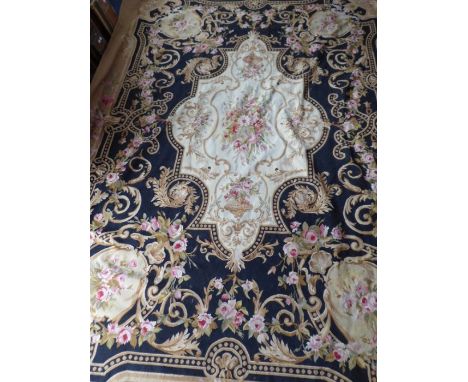 An unlined Aubusson tapestry in a floral geometric pattern in black and beige with a central floral motif on a white ground a