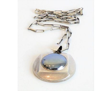 A highly unusual hallmarked silver circular pendant and chain, the pendant with central polished mirror finish cabochon stone