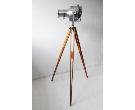 An original mid 20th century Strand 23 polished steel theatre light on an adjustable wooden tripod stand (the light requires 
