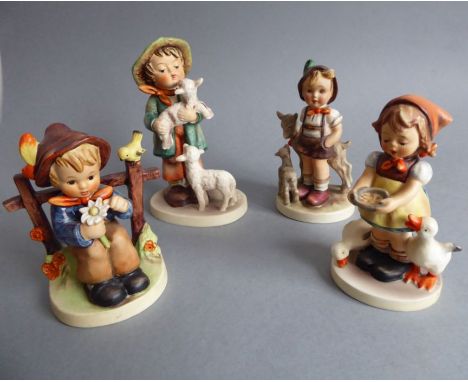 Four hand-decorated West German Goebel figures; in typical style and modelled as children with animals (the tallest 14cm)