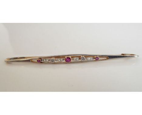 A late 19th/early 20th century 15-carat rose-gold bar brooch centrally set with a ruby flanked by diamonds, diamond chips and
