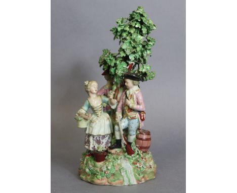 An 18th century Derby porcelain figure group depicting three figures standing around the base of a tree, the male with a rifl