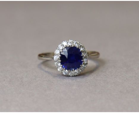 A SAPPHIRE &amp; DIAMOND RING, the oval sapphire measuring approx. 8mm x 7mm x 4.5mm &amp; weighing approx.1.8 carats, set wi