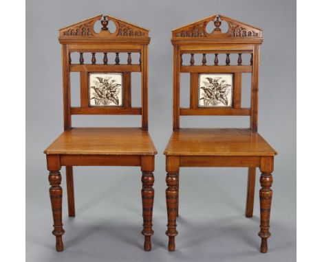 A pair of Victorian mahogany tile-back hall chairs with blind-fret carving, hard seats &amp; on ring-turned front legs.