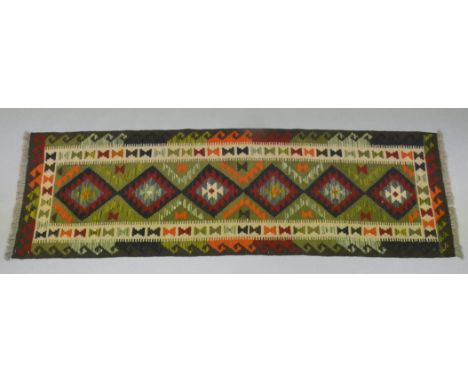A Maimana kilim runner of ochre ground with repeating multi-coloured geometric design &amp; central row of six lozenges, 25” 