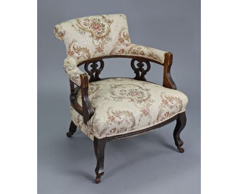 A Victorian tub-shaped armchair with padded seat, back &amp; arms upholstered cream-coloured floral material, with pierced su
